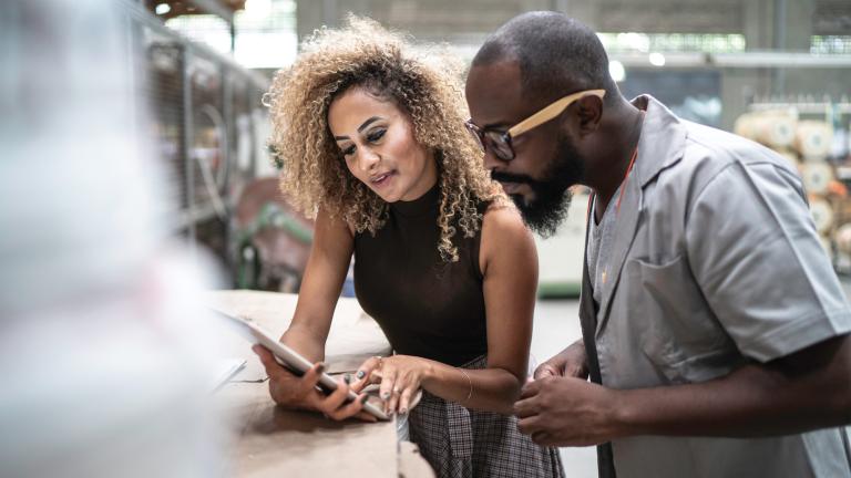 Two young adults discussing something on an iPad